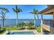 Backyard featuring a sparkling pool, lush lawn, and stunning views of the waterfront and boat dock at 7342 Captain Kidd Ave, Sarasota, FL 34231