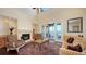 Cozy living room featuring a stone fireplace, comfortable chairs, and a beautiful water view through sliding doors at 7342 Captain Kidd Ave, Sarasota, FL 34231