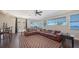 Spacious living room with waterfront views, featuring a large brown leather sofa, bar, and tile flooring at 7342 Captain Kidd Ave, Sarasota, FL 34231