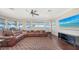 Bright living room with waterfront views and a large brown leather sofa, entertainment center, and tile flooring at 7342 Captain Kidd Ave, Sarasota, FL 34231