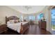 Water view Primary bedroom with access to balcony featuring wood floors and luxury furnishings at 7342 Captain Kidd Ave, Sarasota, FL 34231
