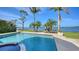 Backyard pool with dock access to the waterway featuring lush landscaping and blue skies at 7342 Captain Kidd Ave, Sarasota, FL 34231
