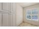 Bright Bedroom featuring white cabinets, tiled floors, and shuttered windows at 7632 Marsh Orchid Cir # 7632, Bradenton, FL 34203
