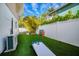 Private fenced backyard featuring an artificial lawn, and outdoor games for Gathering entertainment at 811 Jacaranda Rd, Anna Maria, FL 34216