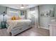 Charming bedroom with light blue walls, a queen-size bed with built-in drawers, and bright, natural light at 811 Jacaranda Rd, Anna Maria, FL 34216