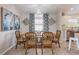 Cozy dining room features a wooden table, blue patterned curtains, and beachy decor at 811 Jacaranda Rd, Anna Maria, FL 34216