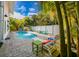 Backyard oasis with a sparkling pool, inviting lounge chairs, and vibrant tropical foliage at 811 Jacaranda Rd, Anna Maria, FL 34216