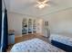 Spacious bedroom with built-in bookshelves and two beds, complemented by modern decor and wood floors at 8314 9Th Avenue Nw Ter, Bradenton, FL 34209
