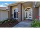 Close-up view of the front entrance, showing an arched window, double doors and lush landscaping at 8314 9Th Avenue Nw Ter, Bradenton, FL 34209