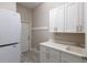 Functional laundry room featuring a washer and dryer, ample storage space, and a utility sink at 8314 9Th Avenue Nw Ter, Bradenton, FL 34209