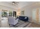 Bright living room with a stylish blue sofa, gray chairs, and sliding glass doors to the patio at 8314 9Th Avenue Nw Ter, Bradenton, FL 34209