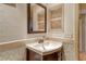 This compact bathroom features a sink with a corner cabinet, a mirror, and tiled walls, optimizing space at 835 S Osprey Ave # 310, Sarasota, FL 34236