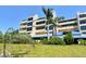 A tropical building exterior with multiple floors, balconies, palm trees, and well-maintained landscaping at 835 S Osprey Ave # 310, Sarasota, FL 34236
