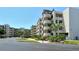 Condo building with manicured landscaping showing circular stairways and covered parking on a sunny day at 835 S Osprey Ave # 310, Sarasota, FL 34236