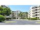 View of a condo building with palm trees and covered parking on a sunny day at 835 S Osprey Ave # 310, Sarasota, FL 34236