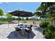 Outdoor seating area with umbrella-covered table, set on a stone patio near the park's water feature at 835 S Osprey Ave # 310, Sarasota, FL 34236