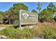 Sign for Oscar Scherer State Park featuring native vegetation and a glimpse of a wooden fence at 835 S Osprey Ave # 310, Sarasota, FL 34236