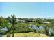 Scenic water view through the lanai screen, showcasing lush landscaping and a serene waterfront setting at 835 S Osprey Ave # 310, Sarasota, FL 34236