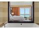 Bathroom view shows the bedroom and ocean through a large, decorative window at 915 Seaside Dr # 405 Weeks 22-23, Sarasota, FL 34242