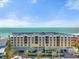 Luxury building with balconies overlooking ocean and beach with rows of palm trees in a sunny landscape at 915 Seaside Dr # 405 Weeks 22-23, Sarasota, FL 34242
