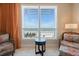 Cozy sitting area with ocean view from large window and two chairs with matching side table at 915 Seaside Dr # 405 Weeks 22-23, Sarasota, FL 34242