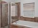 Bathroom with a soaking tub, tiled shower, and window at 11319 82Nd E St, Parrish, FL 34219