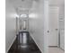 Hallway featuring sleek tile flooring, complemented by an arched entry and access to a convenient laundry room at 11319 82Nd E St, Parrish, FL 34219