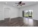 Light-filled living area with wood-look floors, a ceiling fan, and sliding glass doors offering access to the outdoors at 11319 82Nd E St, Parrish, FL 34219