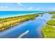 Expansive aerial view showcases the serene beach and winding waterway, offering a picturesque coastal lifestyle at 13644 Brilliante Dr, Venice, FL 34293