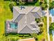 Bird's-eye view of home featuring roof, screened pool, landscaped yard, and beautiful surroundings at 13644 Brilliante Dr, Venice, FL 34293