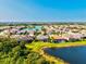 Aerial view showcases a community with a scenic lake, lush landscaping, and beautiful homes at 13644 Brilliante Dr, Venice, FL 34293