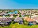 Community aerial view features neighborhood lake, mature landscaping, and well-maintained homes at 13644 Brilliante Dr, Venice, FL 34293