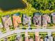 An aerial view highlights homes each with screened-in pools and landscaping, located near a scenic lake at 13644 Brilliante Dr, Venice, FL 34293