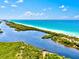 Picturesque aerial view of the beach, waterway, and surrounding landscape for a serene and tranquil coastal experience at 13644 Brilliante Dr, Venice, FL 34293
