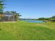 Expansive backyard with lush green grass and serene lake view, ideal for outdoor enjoyment at 13644 Brilliante Dr, Venice, FL 34293