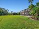 Lush green backyard featuring a screened lanai, offering a private outdoor oasis at 13644 Brilliante Dr, Venice, FL 34293
