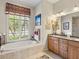 Relaxing bathroom showcases a soaking tub, natural light, double vanity, and modern fixtures at 13644 Brilliante Dr, Venice, FL 34293