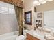 Bathroom featuring a white sink vanity, framed art, and a shower-tub combo with stylish curtains at 13644 Brilliante Dr, Venice, FL 34293