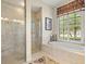 Bright bathroom featuring a tiled walk-in shower, a soaking tub, decorative light fixtures, and natural light at 13644 Brilliante Dr, Venice, FL 34293