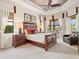 Inviting bedroom featuring tray ceilings, neutral carpet, quality furnishings, and sun-filled windows at 13644 Brilliante Dr, Venice, FL 34293