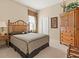 Comfortable bedroom features wood furnishings, neutral walls, cozy carpet, and natural light from large window at 13644 Brilliante Dr, Venice, FL 34293