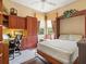 Bedroom features a built-in desk, a murphy bed, and warm-toned wooden cabinets and shelving at 13644 Brilliante Dr, Venice, FL 34293