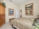 Cozy bedroom featuring carpet flooring, neutral walls, tasteful artwork, and comfortable bedding at 13644 Brilliante Dr, Venice, FL 34293