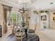 Elegant dining room with chandelier, decorative rug, and view to the landscaped exterior at 13644 Brilliante Dr, Venice, FL 34293