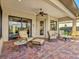 Covered lanai with comfortable seating and a view of the yard and surrounding landscape at 13644 Brilliante Dr, Venice, FL 34293