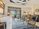 Bright living room with neutral furnishings, tray ceilings, and access to an outdoor pool at 13644 Brilliante Dr, Venice, FL 34293