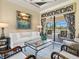 Bright living room with neutral furnishings and access to an outdoor pool through sliding glass doors at 13644 Brilliante Dr, Venice, FL 34293