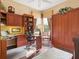 Home office with built-in wooden cabinets, desk, chair, large window, and ceiling fan at 13644 Brilliante Dr, Venice, FL 34293