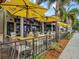 Outdoor dining with tables and yellow umbrellas at 13644 Brilliante Dr, Venice, FL 34293