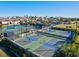 Multiple tennis courts with people playing, surrounded by mature landscaping at 13644 Brilliante Dr, Venice, FL 34293